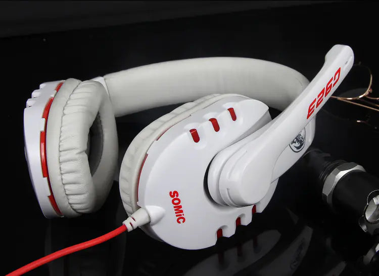 White headphones with red accents on a reflective black surface