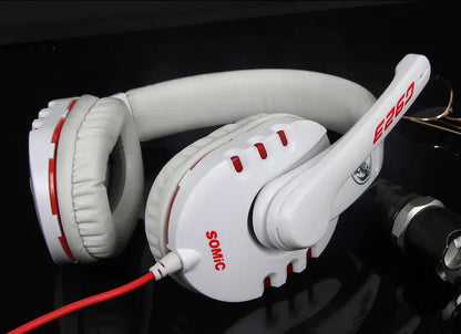 White headphones with red accents on a reflective black surface