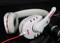 White headphones with red accents on a reflective black surface