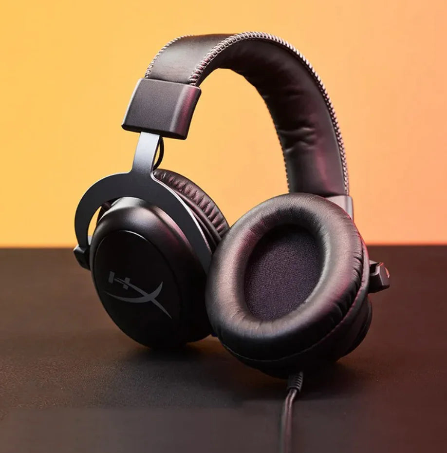 Black headphones on a brown surface with a gradient background